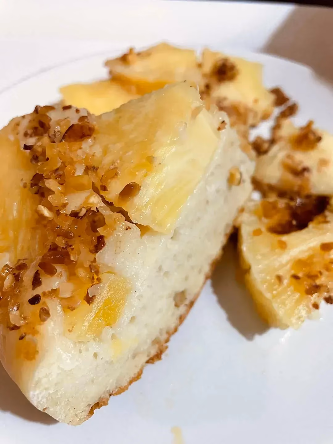 Deux belles parts de ce gâteau au fromage blanc sont présentés sur une assiette de couleur blanche. Le pralin est parsemé sur le dessus.