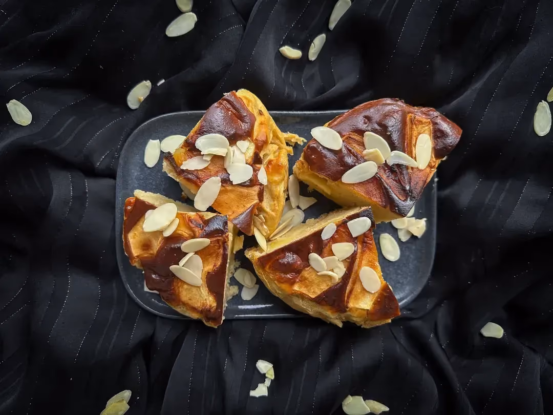Après cuisson ce gâteau aux pommes à l'aspect d'un soufflet. Le topping est constitué de morceaux de pomme coupés sommairement et d'amandes effilées.