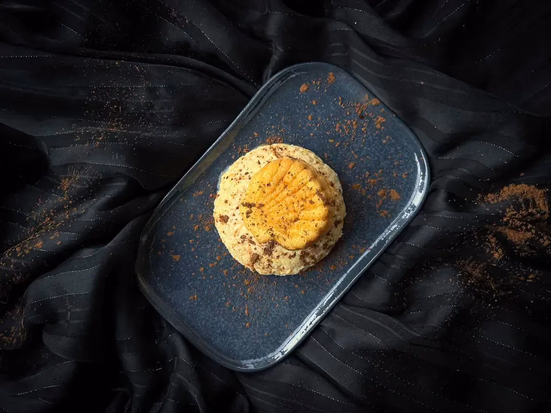 Le gâteau sans cuisson est présenté sur un plat en faïence rectangulaire aux coins arrondis peu profond de couleur bleu foncé.