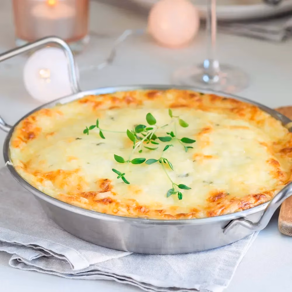 In a round aluminum dish is the Brussels sprouts gratin with poultry bacon.