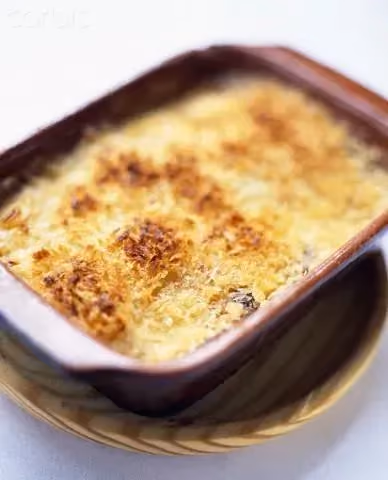 The green papaya and shrimp gratin is in a brown baking dish. It is nicely browned on top thanks to the grated cheese.