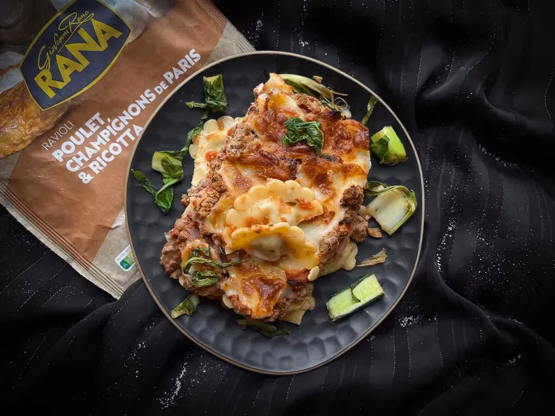 Dans un petit saladier de couleur bleu alvéolé se trouve le Gratin de raviolis au jambon.