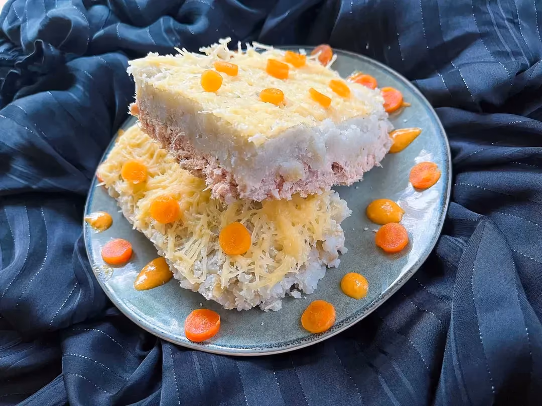 On a blue plate, there are two large portions of sweet potato and tuna shepherd's pie.