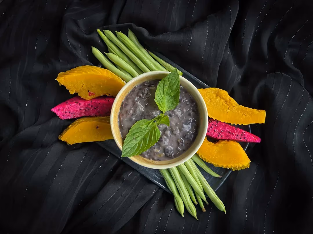 The hummus is presented as a kind of purée, in a large bowl. Thick slices of cucumber are next to it.