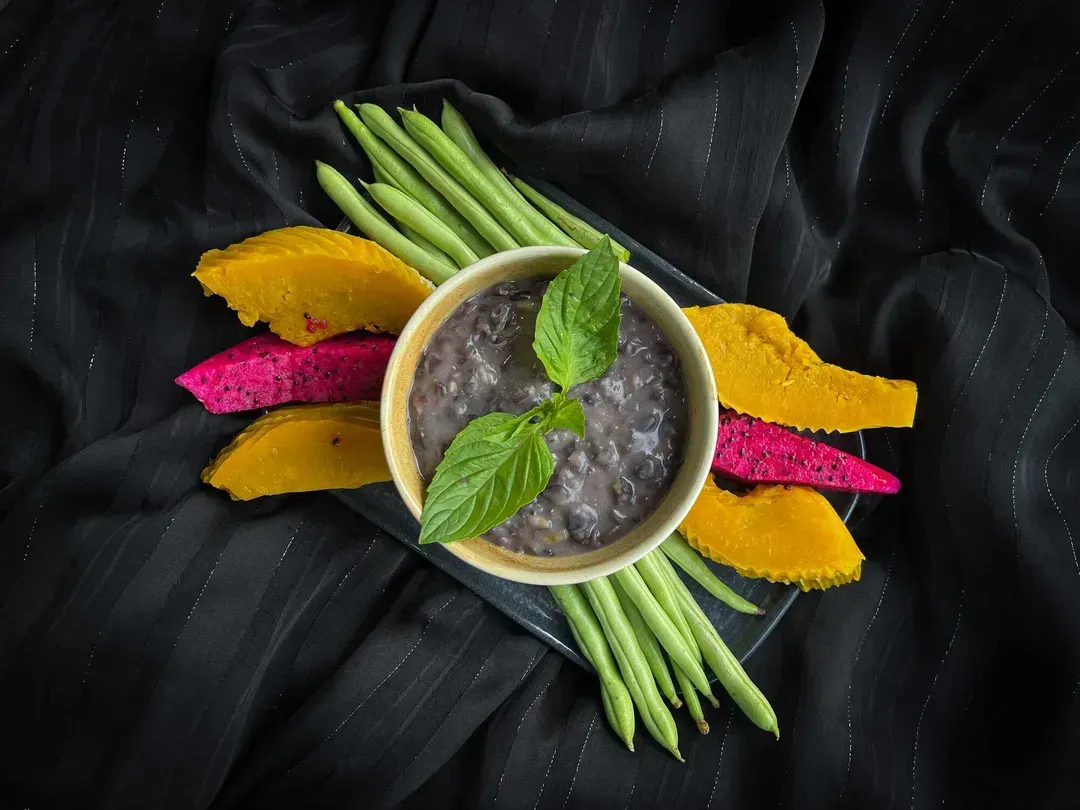 The hummus is presented as a kind of purée, in a large bowl. Thick slices of cucumber are next to it.