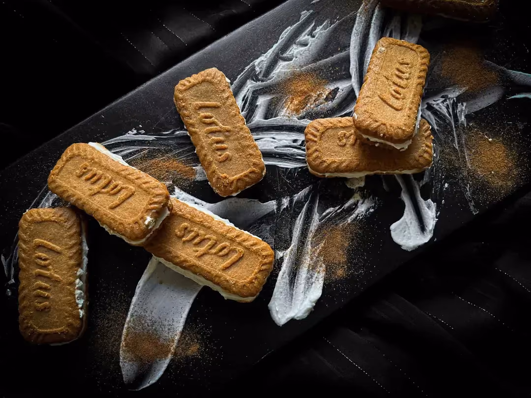 Six ice cream sandwich spéculoos sont disposés sur une belle planche à découper de couleur noire.