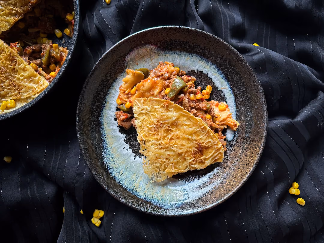 Dans un plat à gratin deux grandes tortillas sont prêtes à recevoir la préparation de viande haché, poivrons, haricots rouges et fromage râpé.
