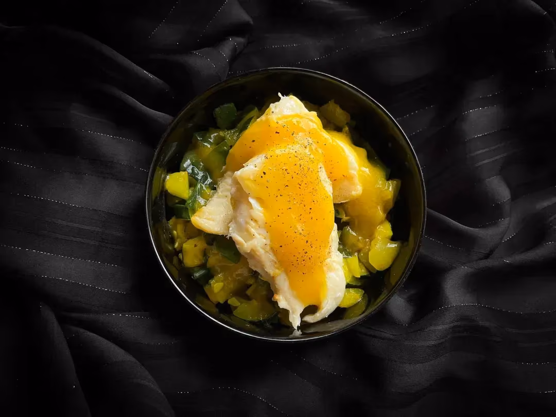 La lotte au beurre, coulis de mangue et courgettes est présentée dans un petit saladier. Le coulis de mangue donne la couleur jaune au plat. Superbe !