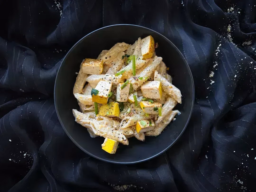 In a small blue earthenware bowl is a revamped tofu macaroni and cheese recipe.
