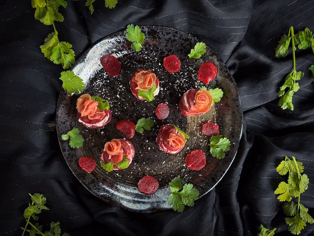The beets are rolled in such a way that they look like little roses. Parsley and cilantro leaves accompany the beets.