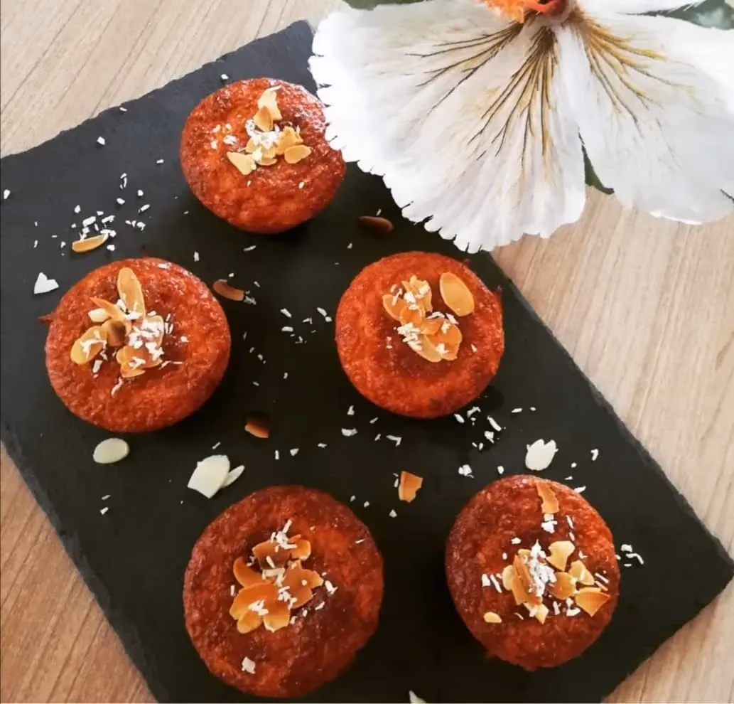 Déposés encore sur la plaque de cuisson, se trouve cinq muffins bien dorés. Le topping est composé de petites amandes effilées