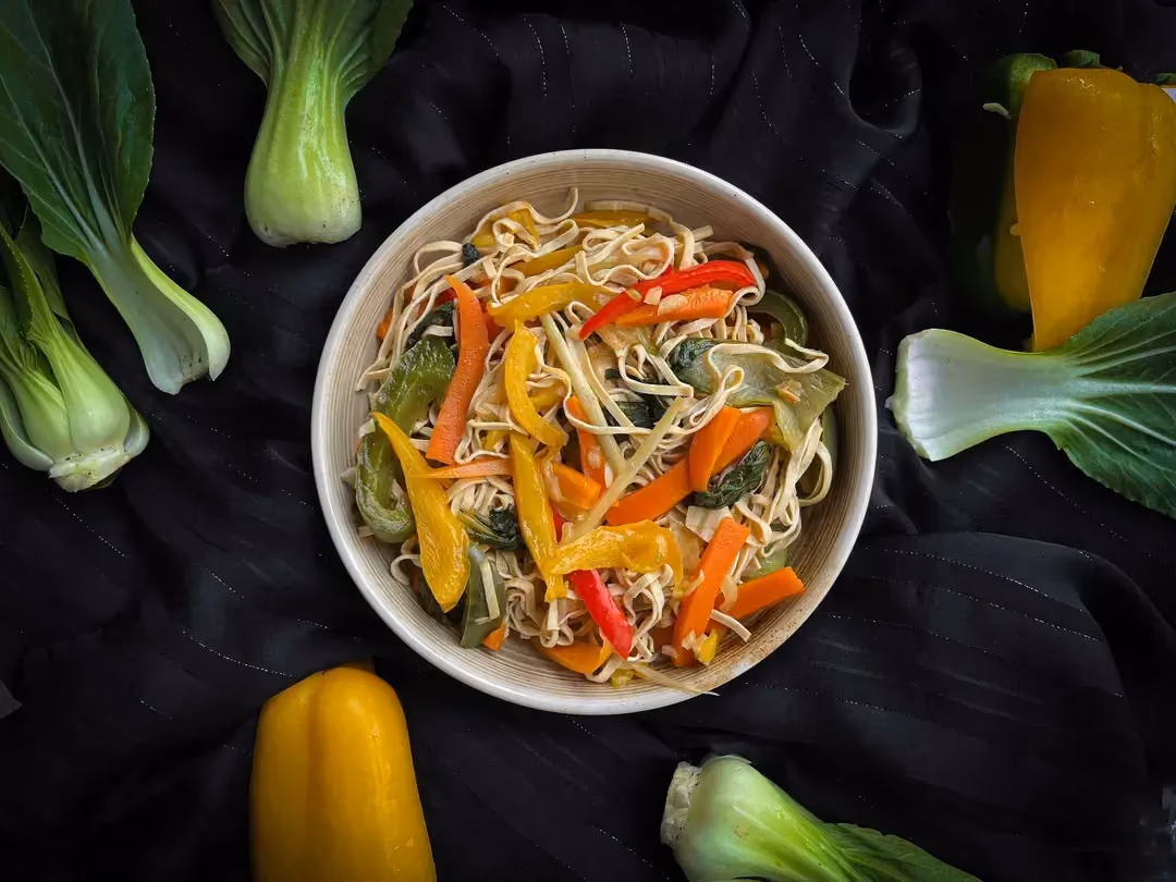 Une poêle très creuse accueille le mélange de nouilles et de légumes pour le plus bel effet visuel. Ce plat est idéal pour mettre en appétit.