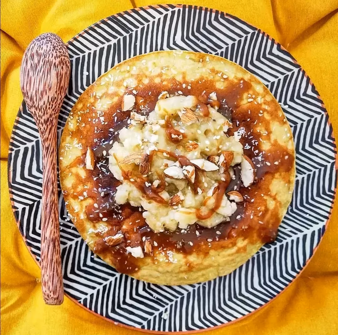 A beautiful blue-and-white striped designer plate showcases this sweet coconut omelet.