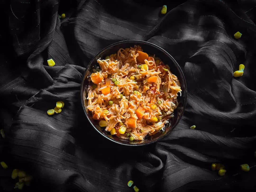 Un petit saladier de couleur bleu sert de réceptacle au One pot pasta, composé de poulet, carottes, maïs et petits pois.