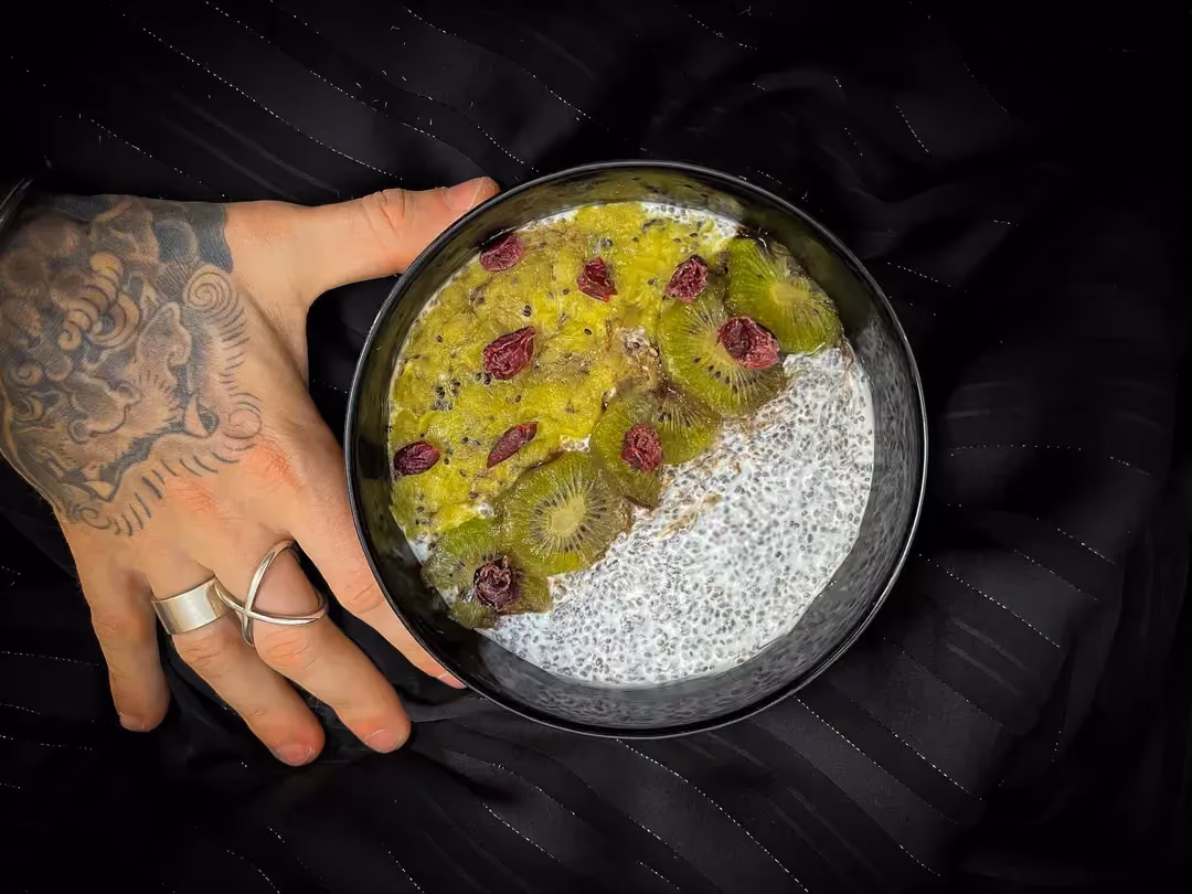 In a bowl are chia seeds that have swollen overnight, covered with kiwis sliced into thin rounds.