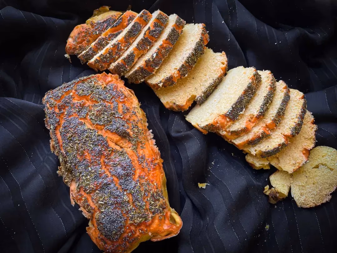 Une douzaine de tranches de pain de lentille corail sont présentées sur un tissus soyeux de couleur bleu.