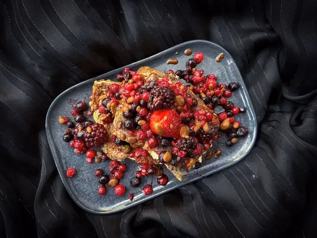 Les tranches de pain perdu aux fruits rouges sont présentées dans un plat de forme rectangulaire peu profond.