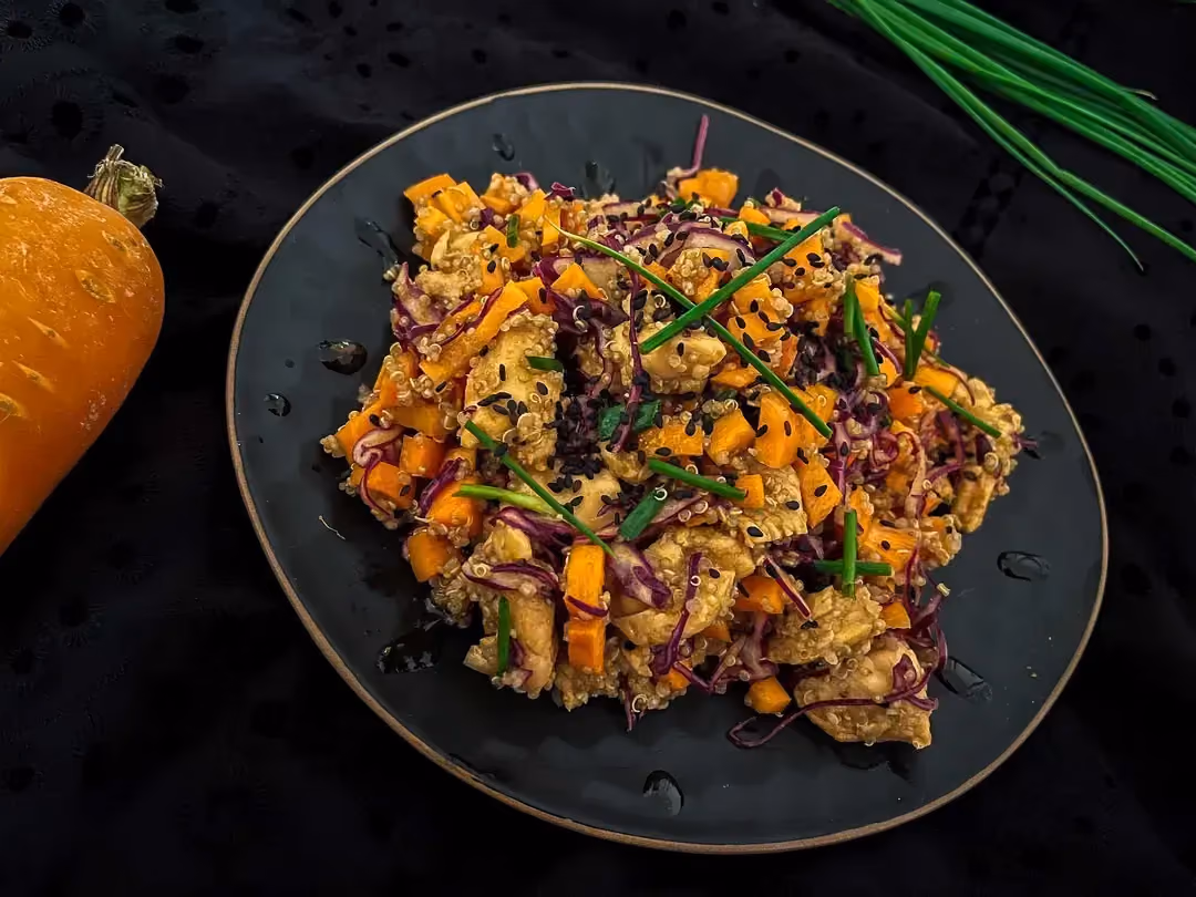 Un jolie plat ovale en faïence de couleur bleu mets en valeur la recette de taboulé de quinoa à l'asiatique.