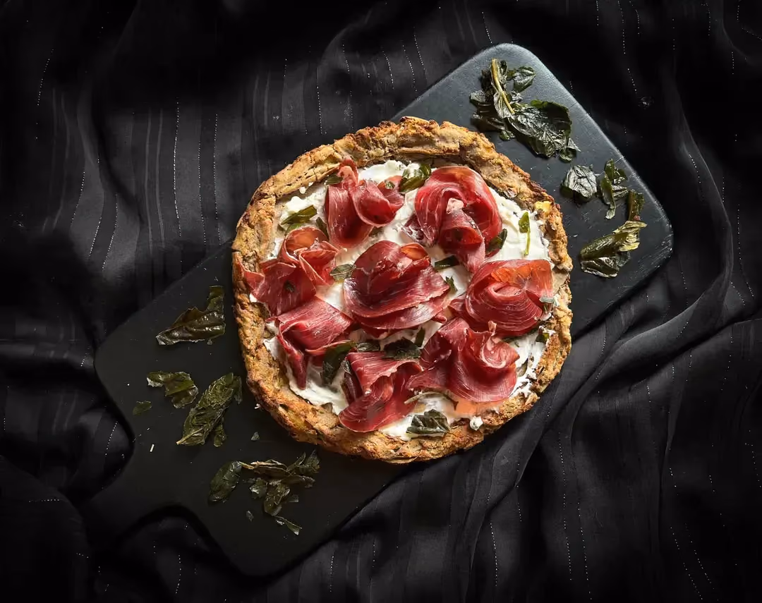 The ricotta tart is topped with rolled dried beef arranged to look like flowers.