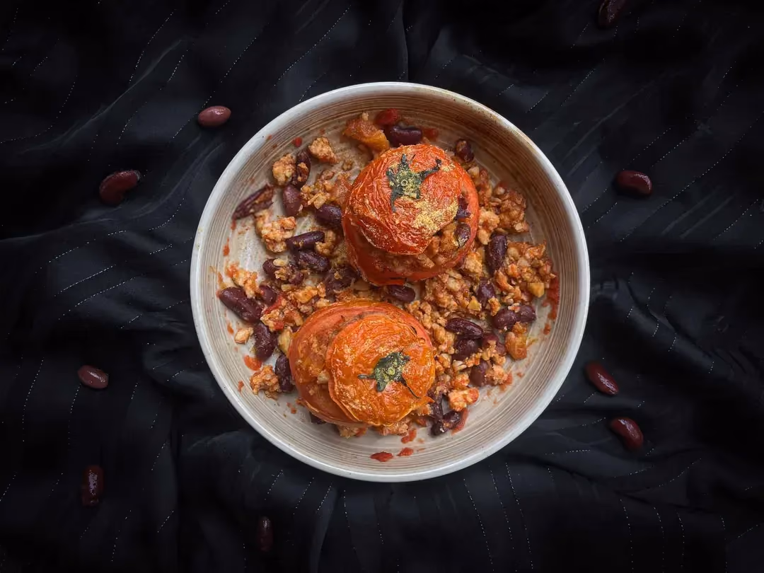 Deux très grosses tomates sont farcies avec du boeuf haché et des haricots rouges.