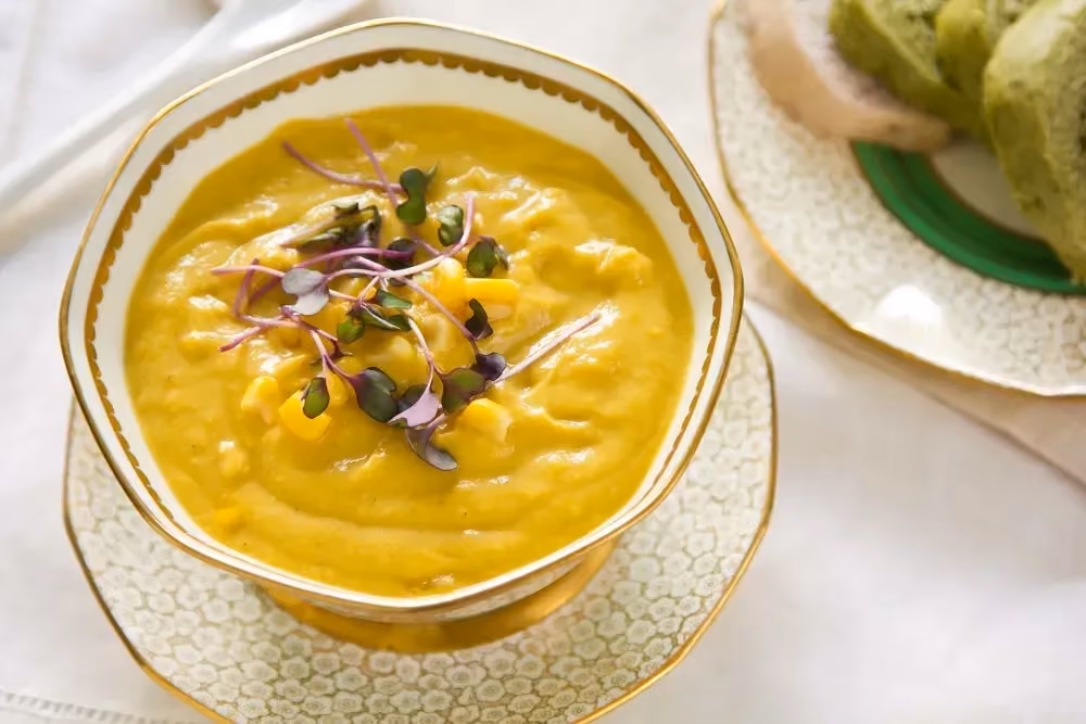 In a beautiful octagonal earthenware soup tureen is a creamy corn soup with chili powder.