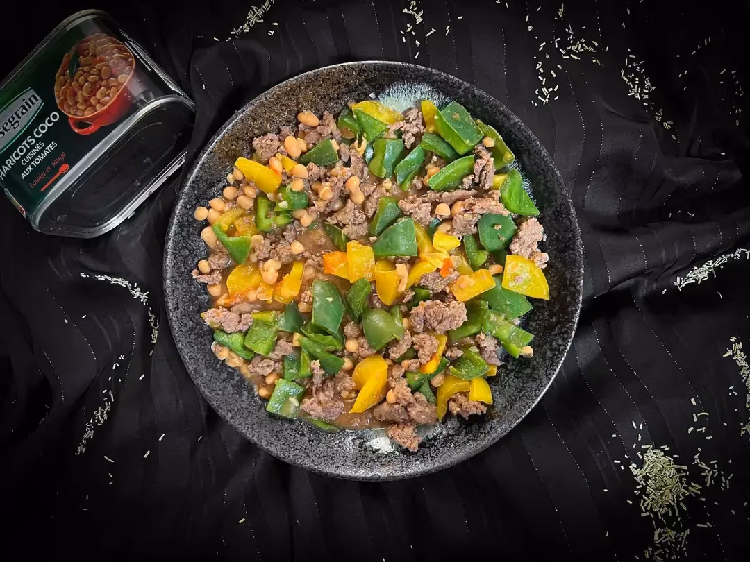 A small blue bowl holds the ground meat, peppers, and coco beans in tomato sauce.