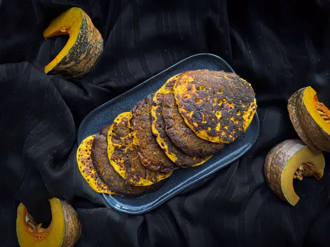 Des pancakes sont disposés les unes sur les autres dans une assiette blanche.