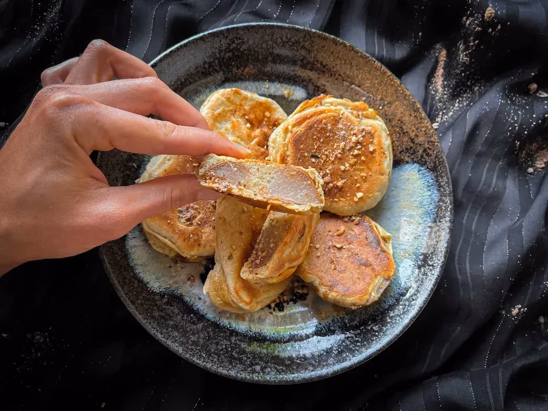 The apple and peanut protein pancakes are presented in a blue bowl.