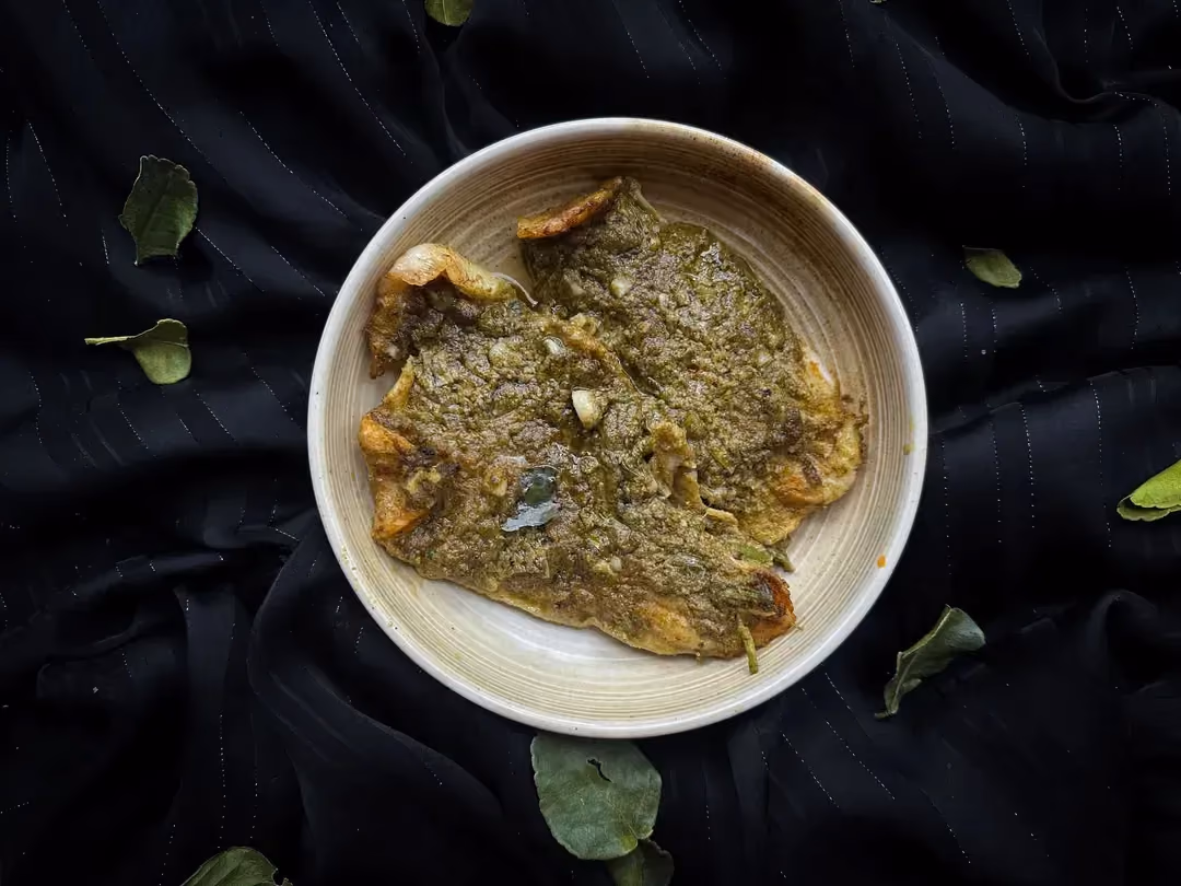 Le filet de cabillaud est recouvert de pesto vert et il est disposé sur un mélange de lentilles et de poivrons.