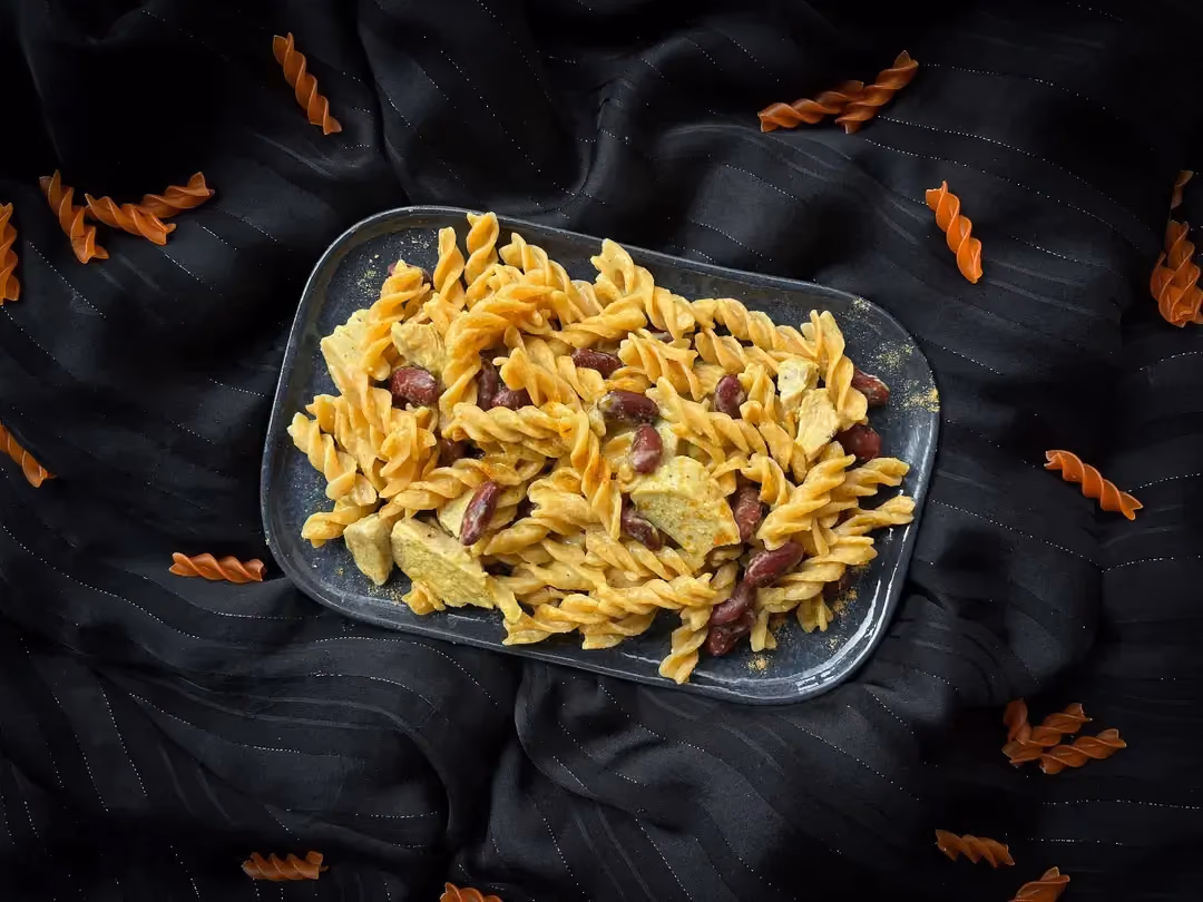 The curry has tinted the creamy pasta, coating the chicken and the rest of the ingredients like coconut and red beans.