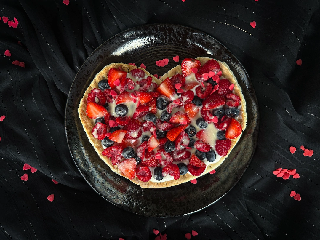 The red berry pizza is presented in a small blue earthenware bowl.