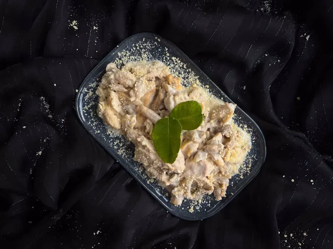 The chicken with button mushrooms is completely coated in Parmesan cream.