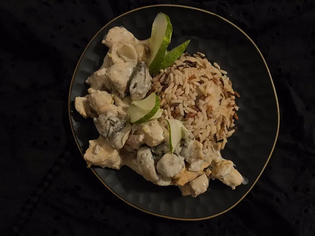 In a large blue bowl, there is chicken and mushrooms, all mixed with skyr and Boursin.