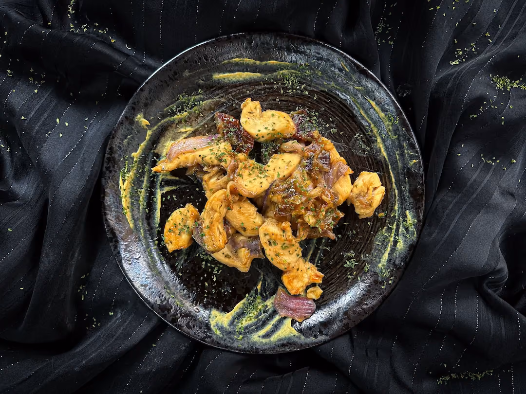 The chicken recipe with shallots, mustard, and honey is presented in a small blue earthenware bowl.