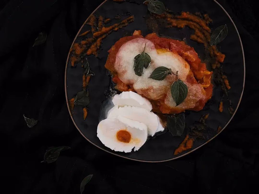 In a small bowl, you can see chicken coated in a tomato and mozzarella sauce.