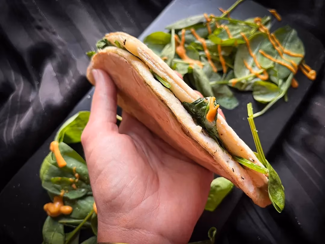We’re holding the quick egg white, shredded cheddar, and spinach quesadilla in our hand.