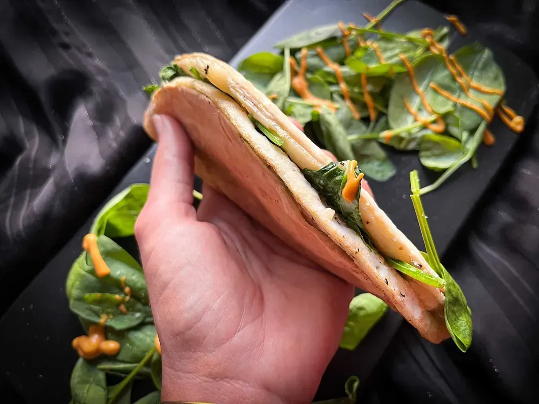 We’re holding the quick egg white, shredded cheddar, and spinach quesadilla in our hand.