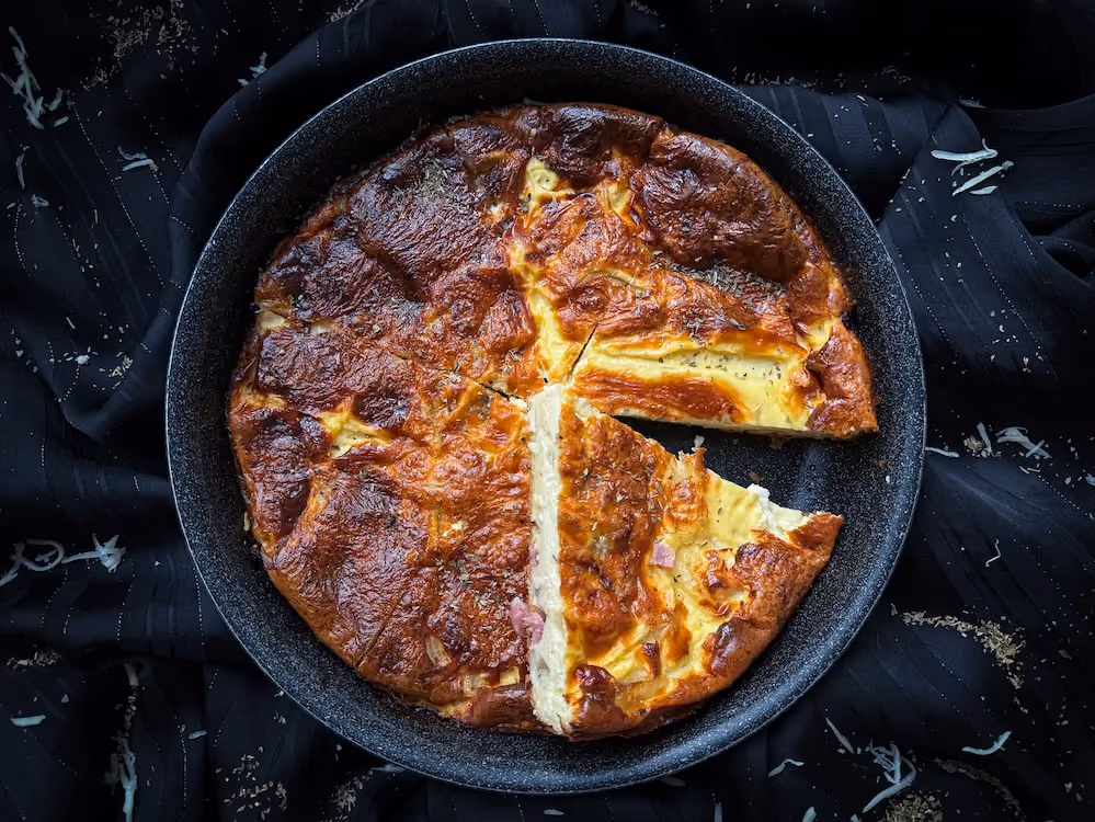 In a white pie dish, the crustless quiche Lorraine appears before us, beautifully golden brown.