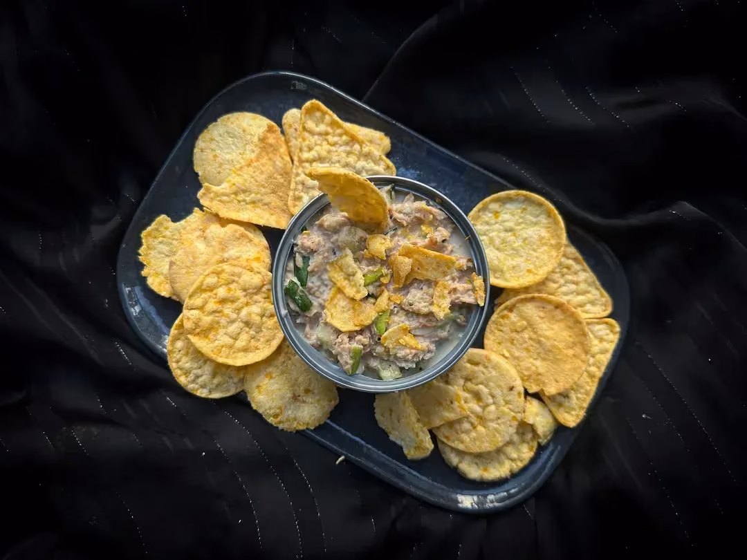 The tuna rillettes are placed in a "Le Parfait" glass jar. Small toasts are already ready. Green and black olives are on the side.