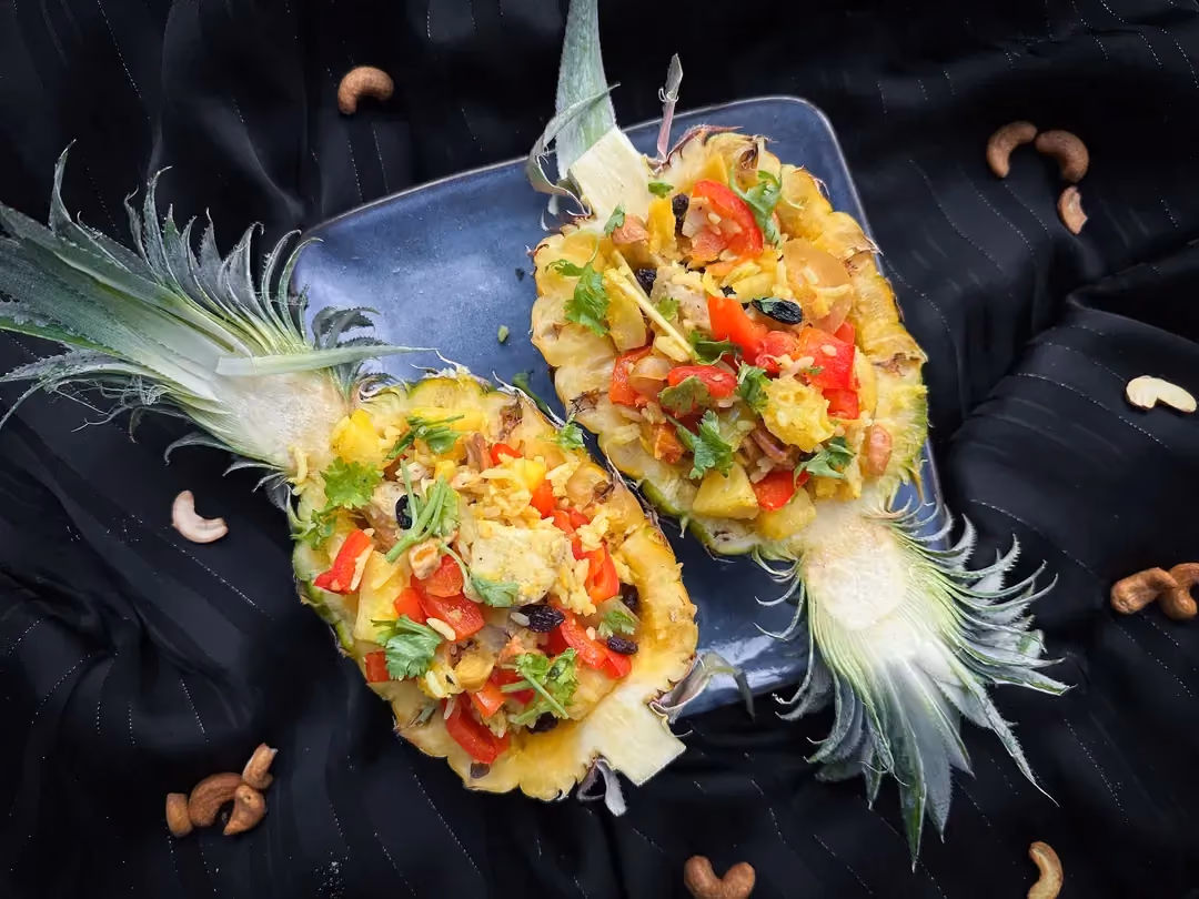 Un ananas coupé en deux et vidé de sa chair sert de réceptacle à cette recette de riz sauté à l'ananas. Effet visuel garanti !