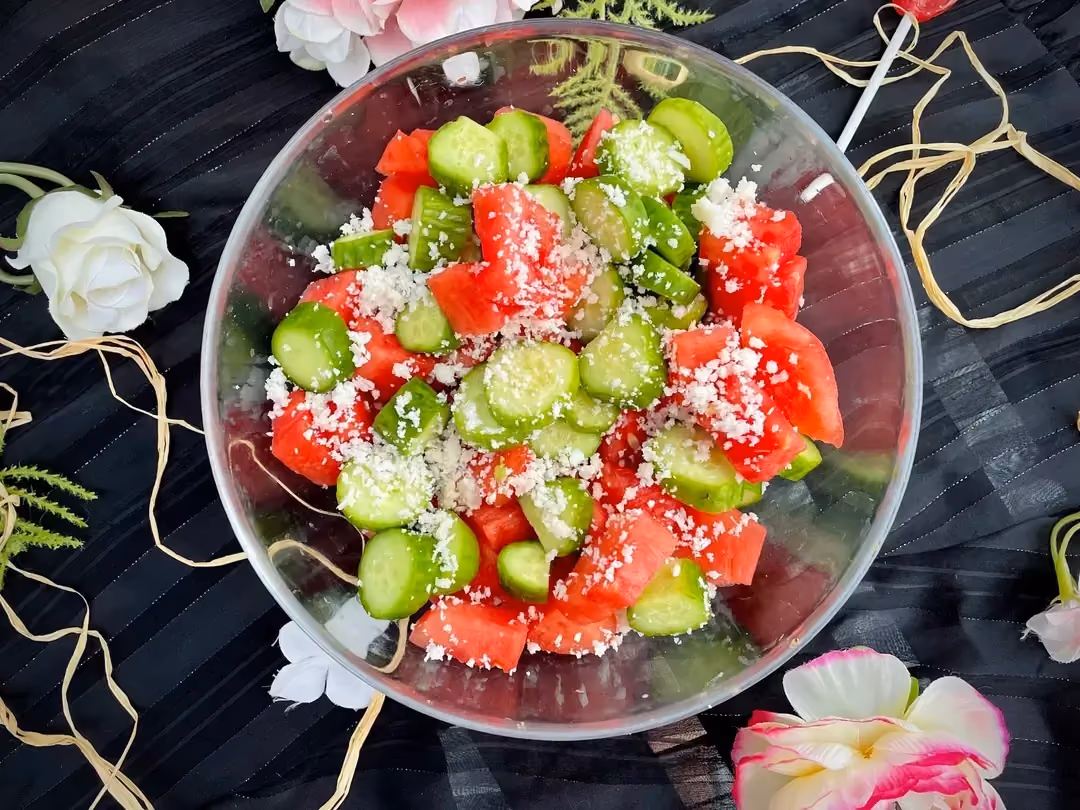 Dans un grand saladier transparent, on retrouve les couleurs de l'été avec le rouge de la pastèque et le vert des concombres. Le coco râpé pour finir.