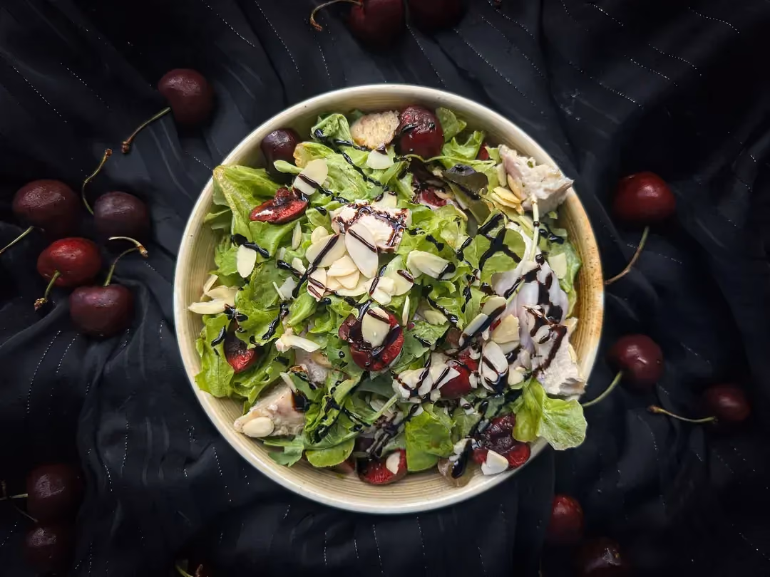 In a rectangular glass dish with rounded corners is the chicken salad with curry, tarragon, and cherries.