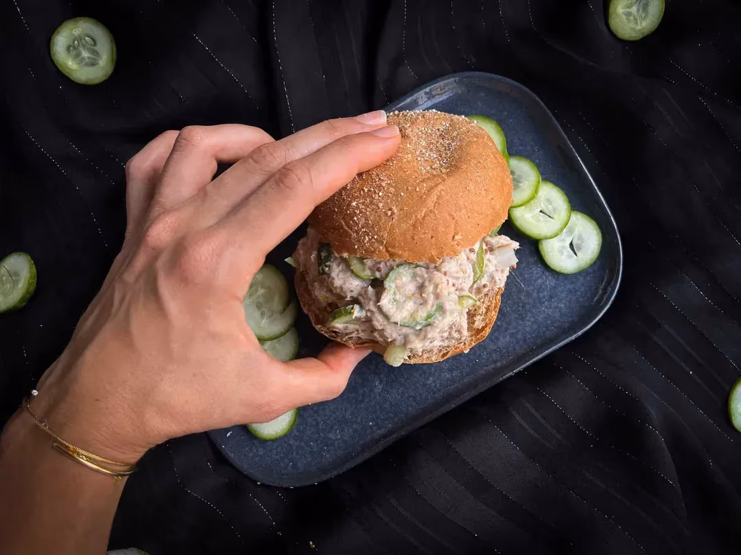 In Maelle's hand is the tuna, fromage blanc, and cucumber sandwich bun.