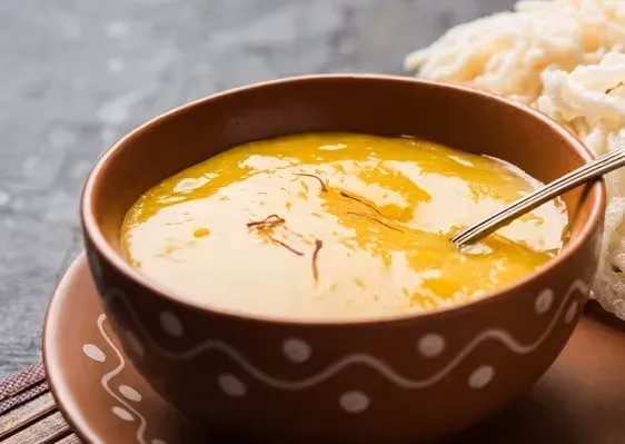 The exotic salad dressing is presented in a beautifully decorated brown bowl.