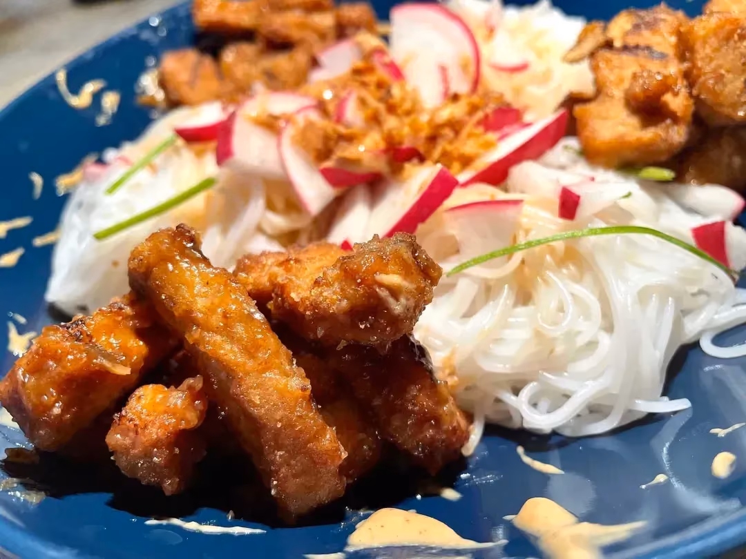 The soy, peanut butter, and maple syrup recipe is presented on a beautiful blue plate.