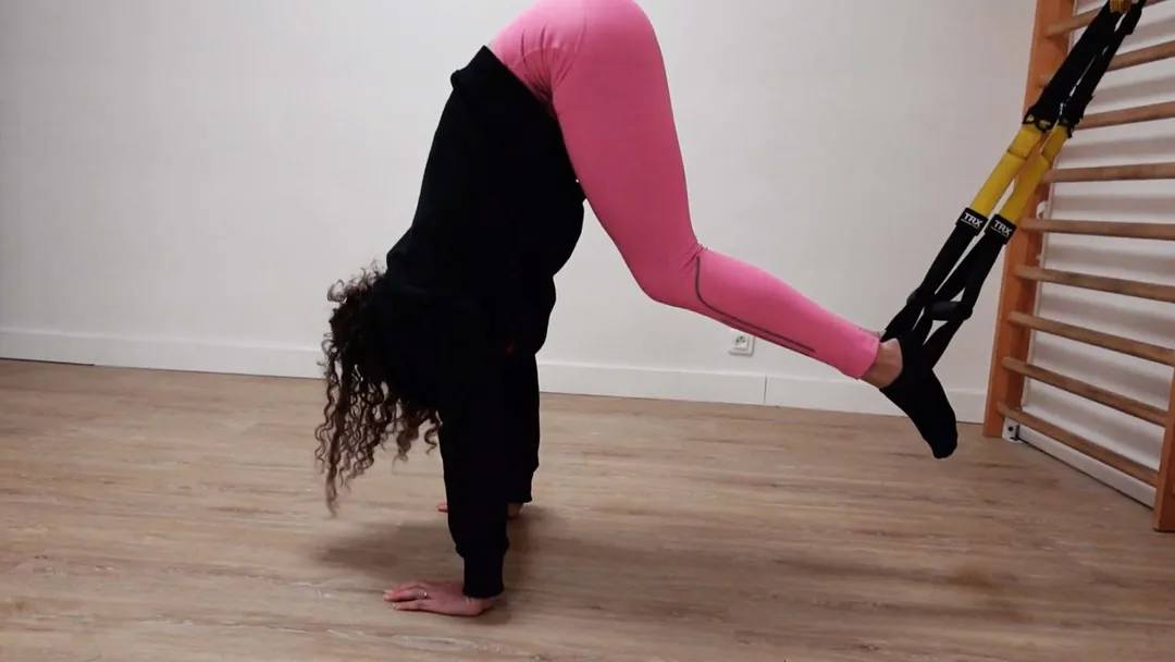 Pike abdominal, mains au sol et pieds suspendus dans les sangles du TRX.