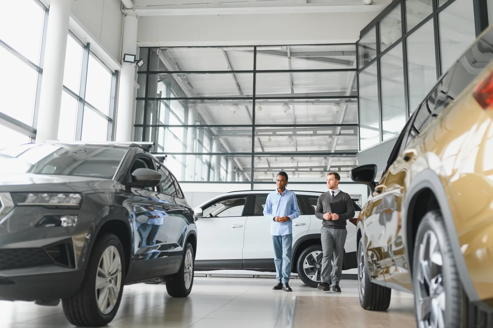 Modern car dealership showroom salesman and customer