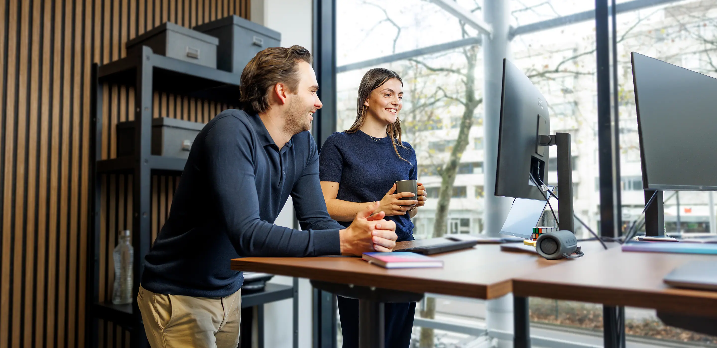 2 people discussing behind a computer screen