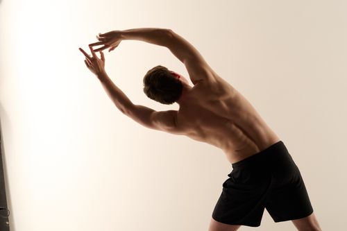 Male Pilates figure posing in a deep lateral stretch