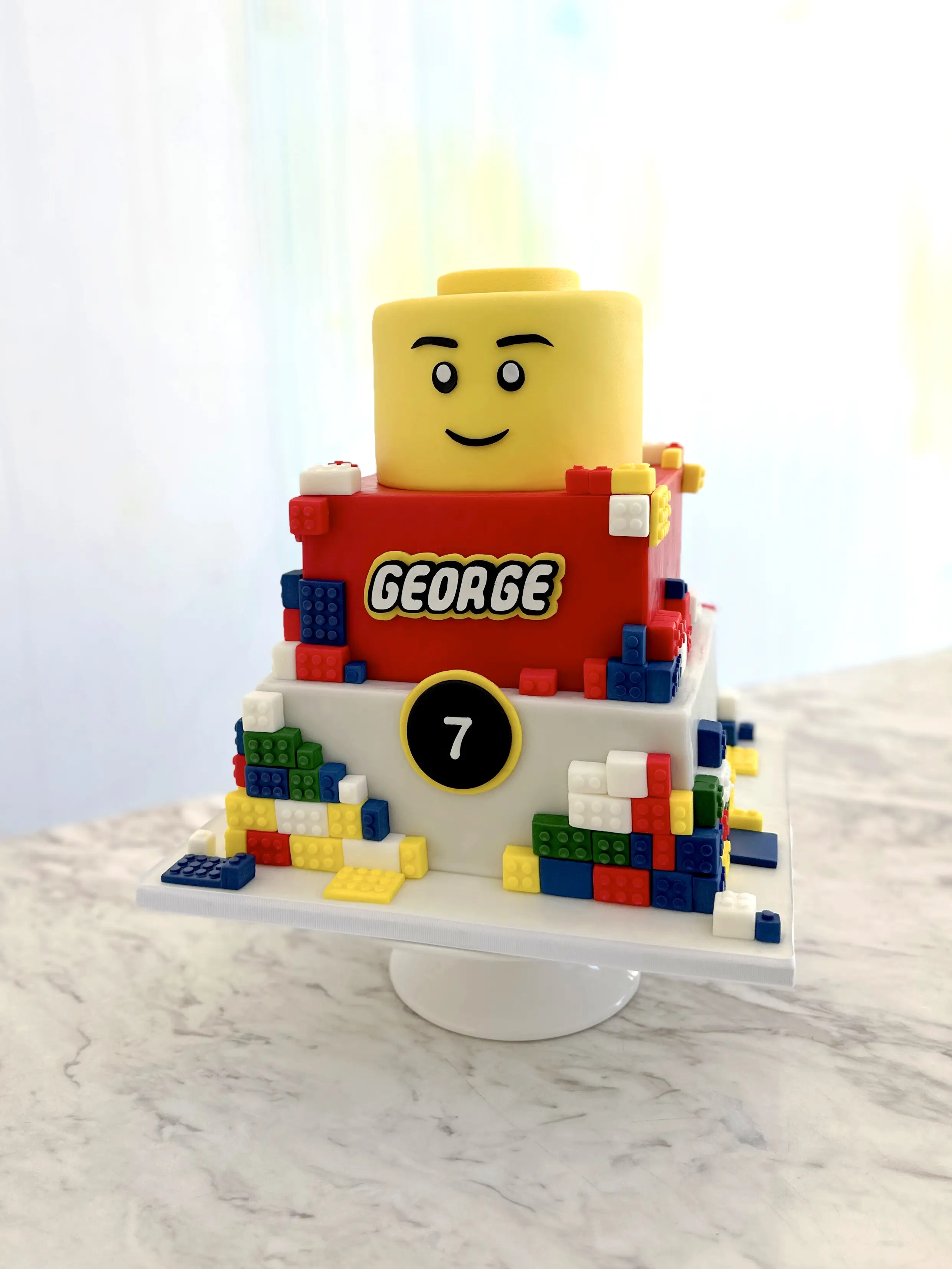Lego themed boys birthday cake with personalised name george and number 7, colourful kids cake design in cyprus